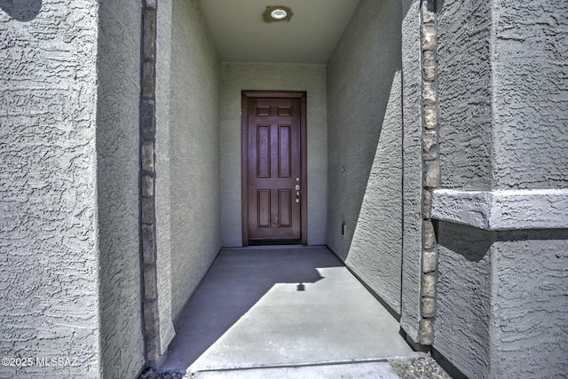 entrance to property featuring stucco siding