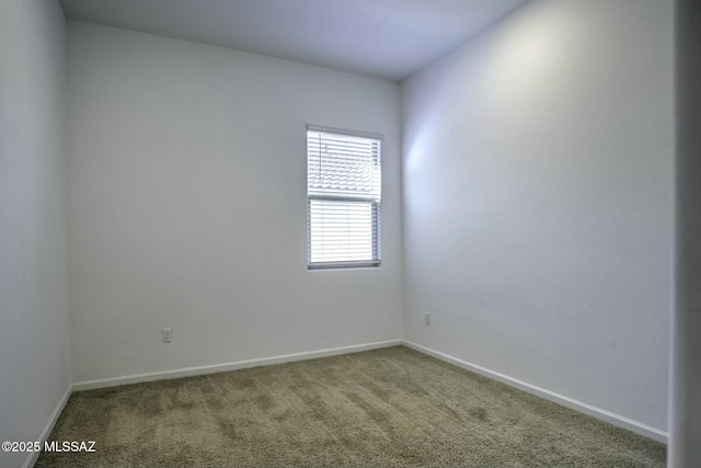 spare room featuring carpet flooring and baseboards