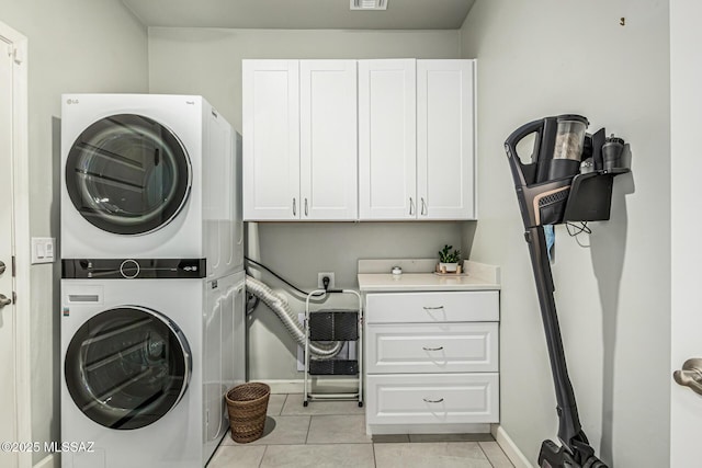 8707 N Ash Grove Ct, Tucson, AZ 85742 - laundry area with stacked washer / drying machine, cabinet space, light tile patterned floors, and an office area