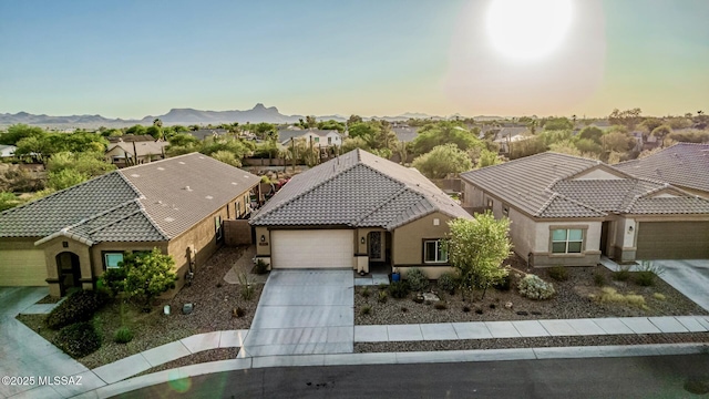 8707 N Ash Grove Ct, Tucson, AZ 85742 - view of front facade featuring an attached garage, driveway, stucco siding, a tile roof, and a residential view