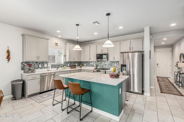 8707 N Ash Grove Ct, Tucson, AZ 85742 - kitchen with appliances with stainless steel finishes, decorative backsplash, light countertops, a kitchen island, and recessed lighting