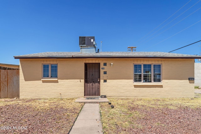 ranch-style house featuring brick siding, central AC, and fence