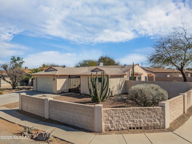 view of front of home featuring a garage, stucco siding, driveway, and fence