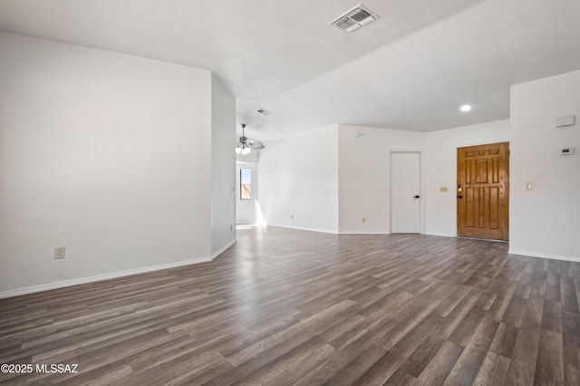 spare room featuring dark wood finished floors, visible vents, a ceiling fan, and baseboards