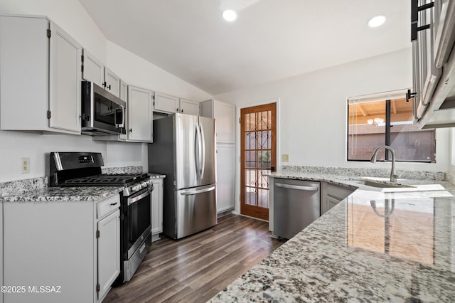 kitchen with light stone counters, dark wood-style floors, lofted ceiling, recessed lighting, and stainless steel appliances