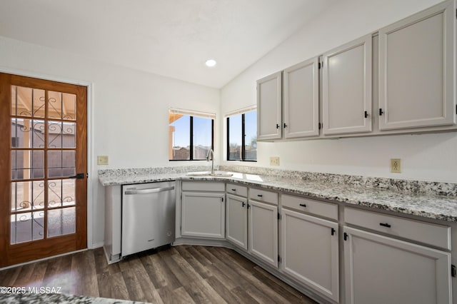 kitchen with light stone counters, lofted ceiling, dark wood-style flooring, a sink, and stainless steel dishwasher