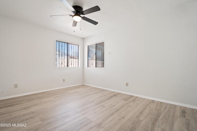 empty room featuring a ceiling fan, light wood-type flooring, and baseboards