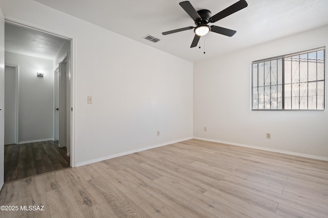 unfurnished room with baseboards, visible vents, and light wood finished floors