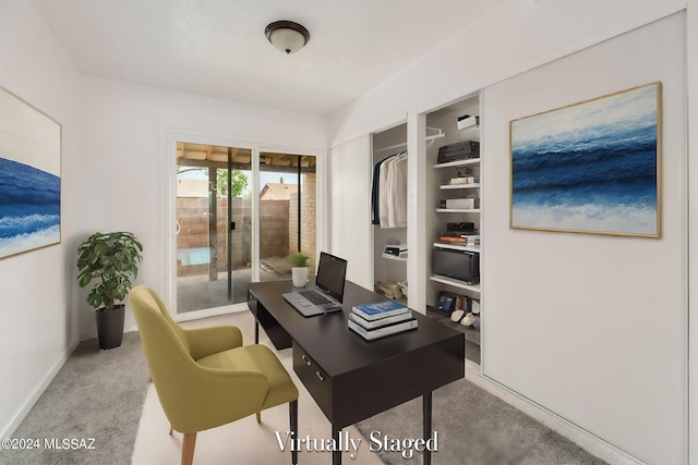 home office with baseboards, built in shelves, and carpet flooring