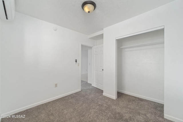 unfurnished bedroom with carpet, baseboards, a closet, and a textured ceiling