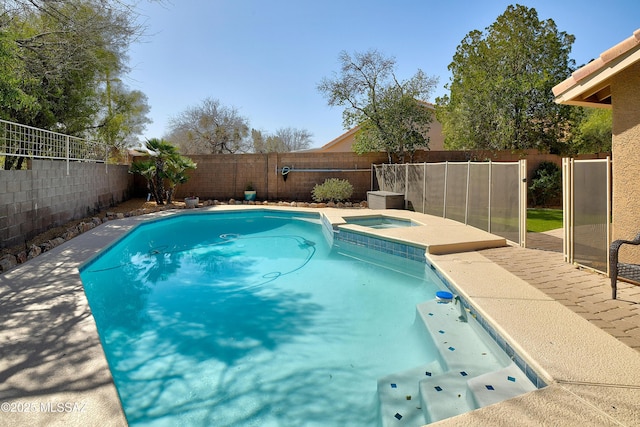 view of swimming pool featuring a fenced backyard and a pool with connected hot tub