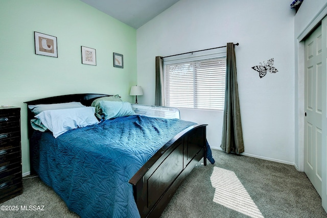 carpeted bedroom with a closet and baseboards