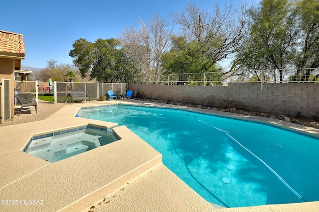 view of swimming pool featuring a patio area, a pool with connected hot tub, and a fenced backyard