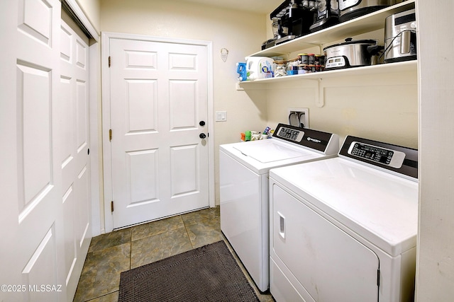 laundry area featuring laundry area, washing machine and dryer, and stone finish flooring