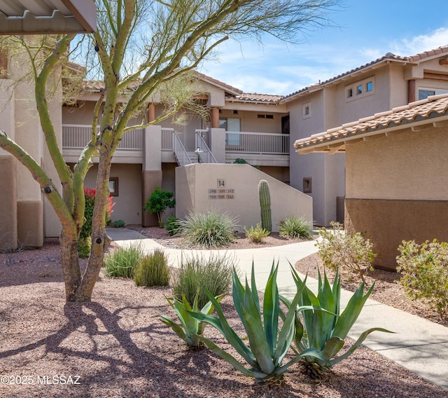 exterior space featuring a tiled roof and stucco siding