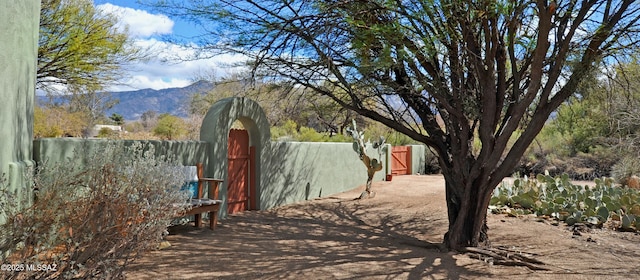 view of yard featuring a gate, a mountain view, and fence