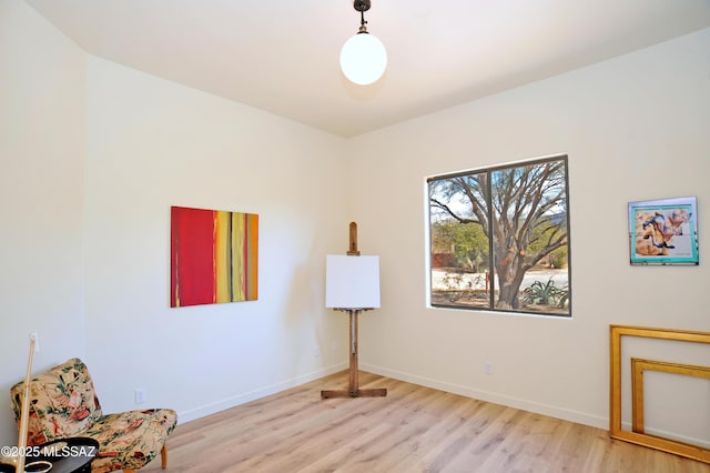 sitting room with baseboards and wood finished floors