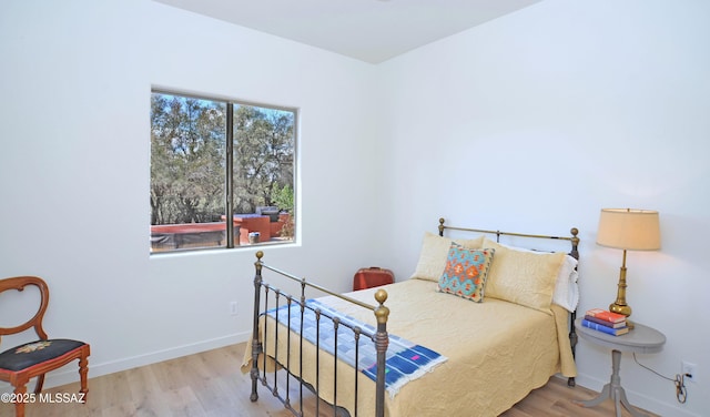 bedroom featuring wood finished floors and baseboards