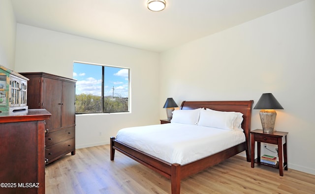 bedroom with baseboards and light wood-style flooring