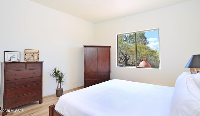 bedroom with baseboards and light wood finished floors