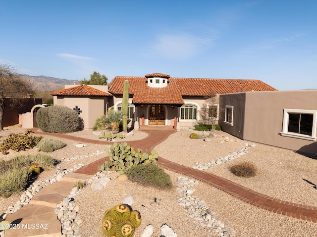 view of front facade featuring stucco siding and a tile roof