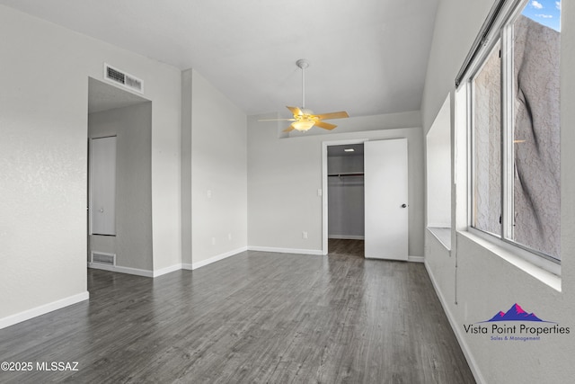 interior space with visible vents, a ceiling fan, and dark wood-style flooring