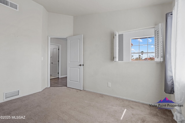 carpeted empty room featuring visible vents