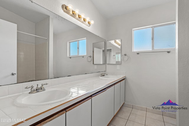 full bathroom with tile patterned flooring, double vanity, and a sink