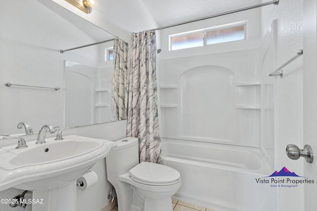 full bath with tile patterned flooring, toilet, shower / bath combo with shower curtain, and a sink