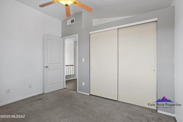 unfurnished bedroom with visible vents, ceiling fan, lofted ceiling, carpet flooring, and a closet