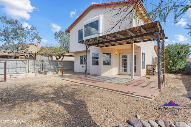 rear view of property featuring stucco siding, a patio, and fence