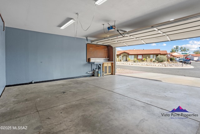 garage with a garage door opener and baseboards