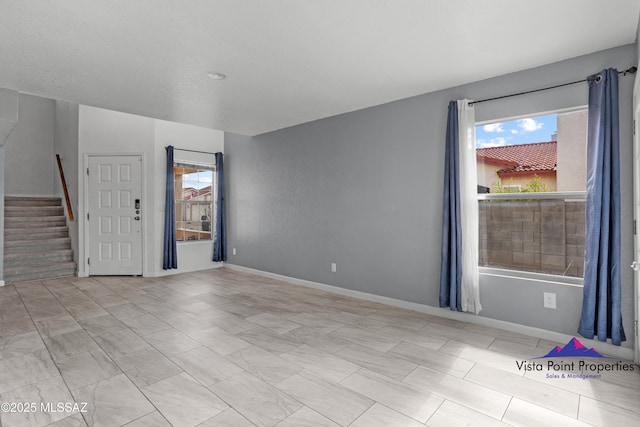 interior space with stairway and baseboards