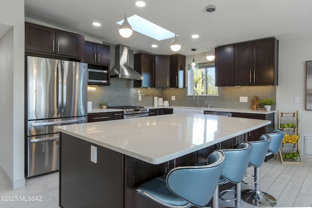 5391 W El Camino Del Cerro, Tucson, AZ 85745 - kitchen featuring appliances with stainless steel finishes, wall chimney exhaust hood, a sink, a center island, and dark brown cabinetry