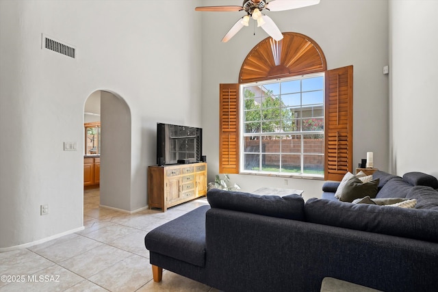 715 W Annandale Way, Tucson, AZ 85737 - living room featuring a towering ceiling, arched walkways, a ceiling fan, light tile patterned floors, and healthy amount of natural light