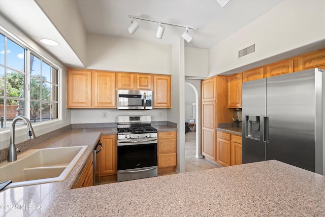 715 W Annandale Way, Tucson, AZ 85737 - kitchen with stainless steel appliances, a sink, light tile patterned flooring, track lighting, and arched walkways