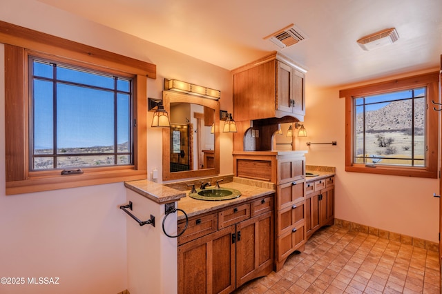 8060 E Diamondback Rd, Saint David, AZ 85630 - kitchen featuring a sink, baseboards, visible vents, and brown cabinets