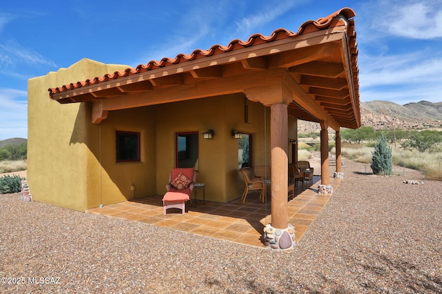 8060 E Diamondback Rd, Saint David, AZ 85630 - rear view of property with stucco siding, a mountain view, and a patio area
