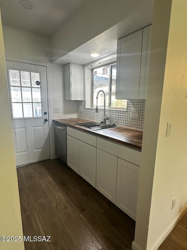 kitchen featuring a sink, backsplash, stainless steel dishwasher, butcher block counters, and dark wood-style flooring