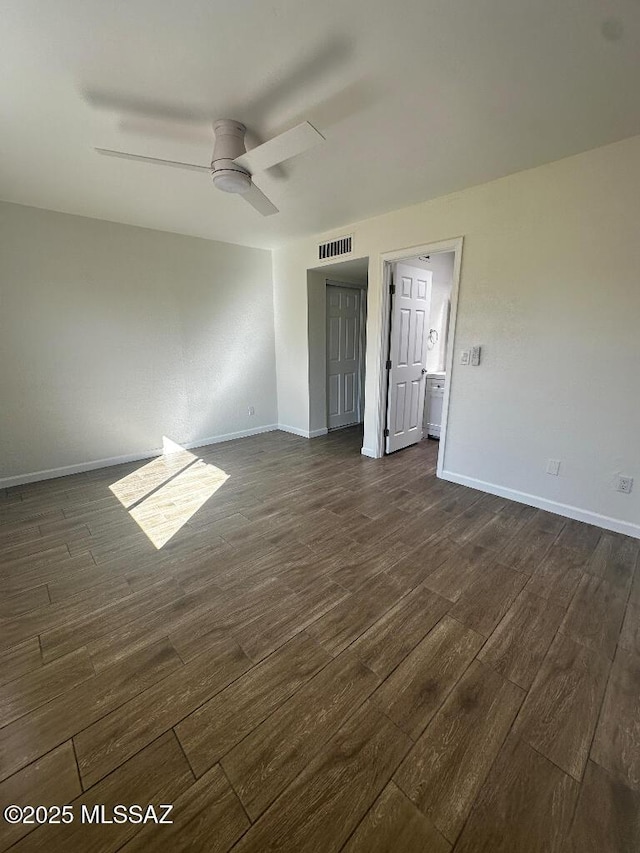 unfurnished room with dark wood-type flooring, visible vents, baseboards, and ceiling fan