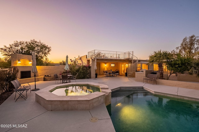 view of swimming pool featuring a patio, fence, outdoor dining area, stairs, and an outdoor fireplace