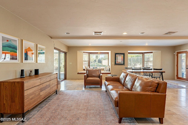 living area with a wealth of natural light, visible vents, and recessed lighting