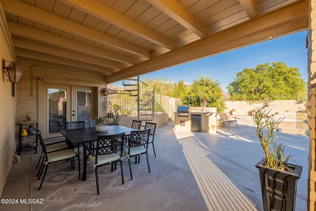 view of patio featuring a grill, outdoor dining area, a fenced backyard, and an outdoor kitchen