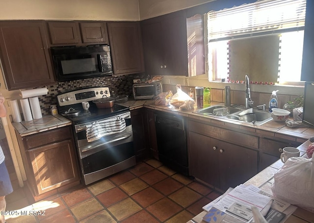 kitchen with black appliances, a sink, dark brown cabinetry, decorative backsplash, and tile counters