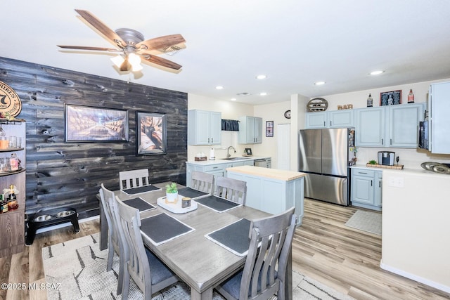 dining room featuring an accent wall, light wood-style flooring, recessed lighting, and a ceiling fan