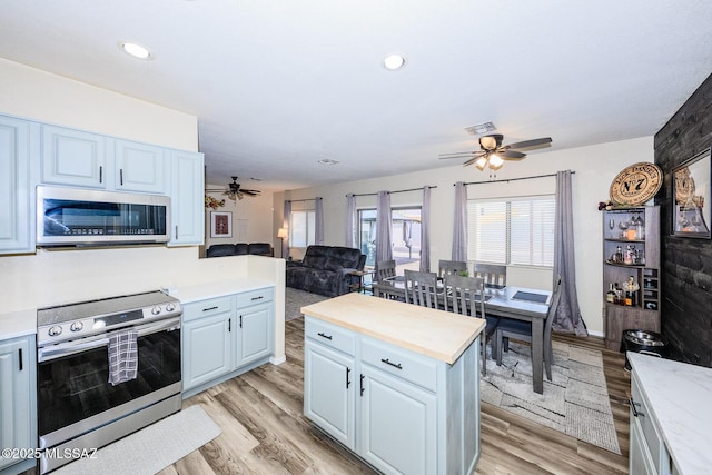 kitchen with visible vents, stainless steel appliances, light wood-style floors, and a ceiling fan