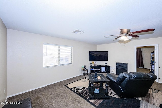 living area featuring ceiling fan, carpet, visible vents, and baseboards