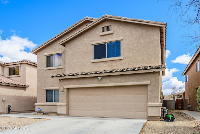 view of front facade featuring fence, a garage, driveway, and stucco siding