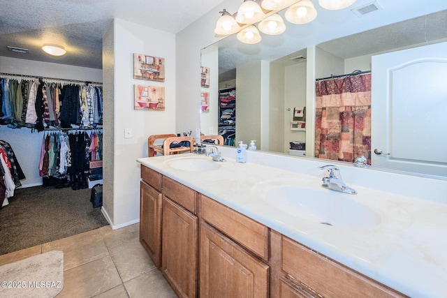 full bathroom featuring tile patterned flooring, double vanity, visible vents, and a sink