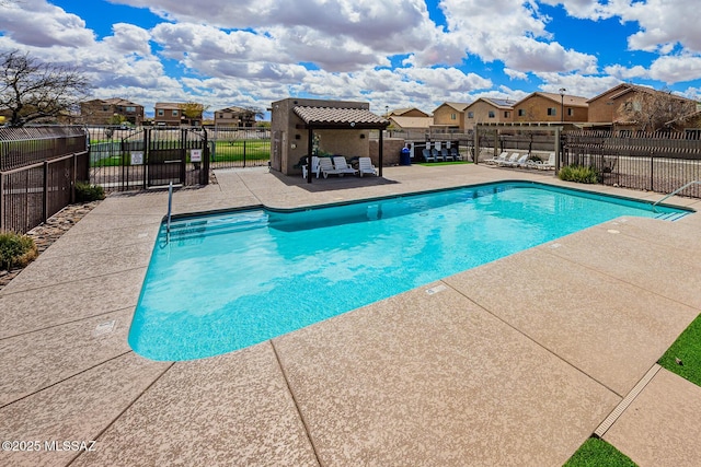 pool featuring a residential view, a patio, and fence